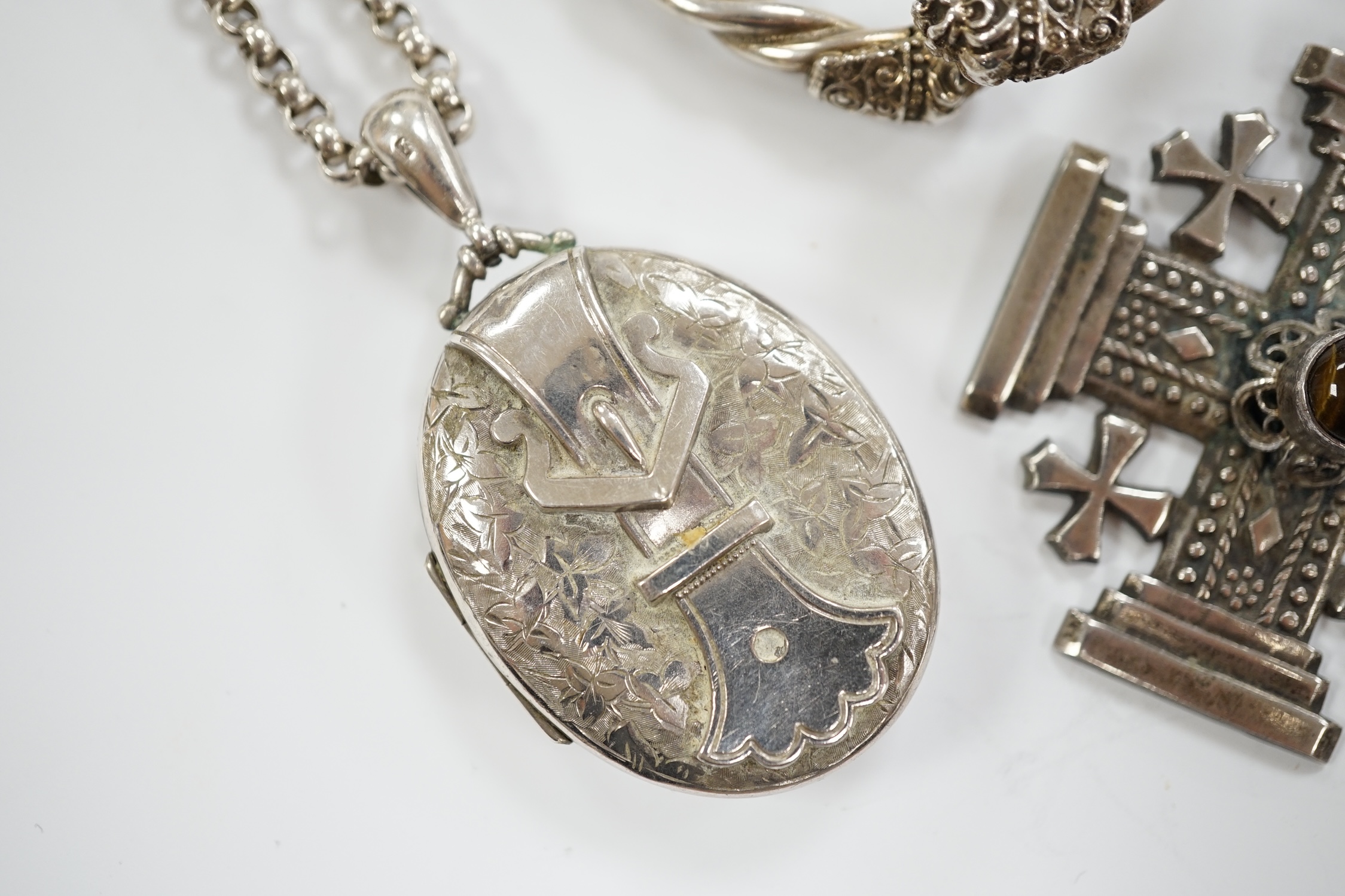 Sundry jewellery including a Victorian silver oval 'buckle' locket, overall 61mm, on a white metal belcher link chain, a continental 950 white metal and banded agate cabochon set cross pendant, a 1930's silver gilt and e